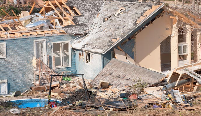 aftermath of a tornado damaged wood framed house